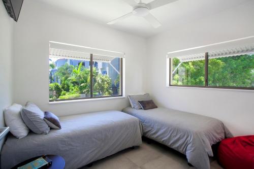 two beds in a room with two windows at Aarons Luxury Retreat in Noosaville
