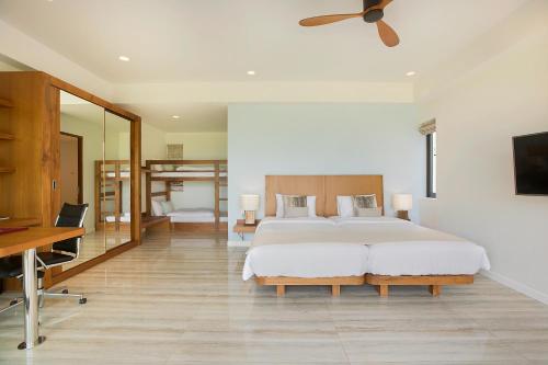 a bedroom with a large bed and a desk at Villa SeaNest Samui in Laem Sor