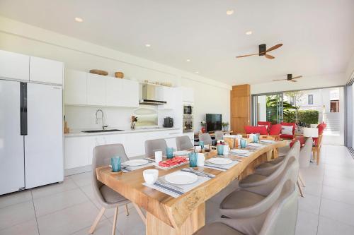 a dining room with a long wooden table and chairs at Villa SeaNest Samui in Laem Sor