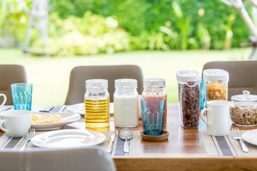 a wooden table with jars of food and drinks at Villa SeaNest Samui in Laem Sor