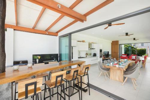 an open kitchen and living room with a table and chairs at Villa SeaNest Samui in Laem Sor