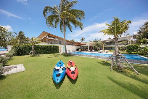 two kayaks sitting on the grass in front of a house at Villa SeaNest Samui in Laem Sor