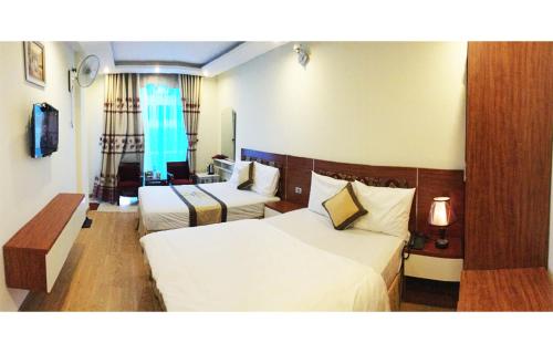 een hotelkamer met 2 bedden en een televisie bij Hoang Gia Hotel in Thanh Hóa