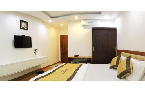 a bedroom with a bed with a tv on the wall at Hoang Gia Hotel in Thanh Hóa