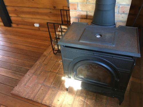 a stove sitting on a wooden floor in a room at Vila Migla in Pašekščiai