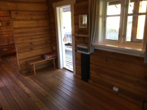 an empty room with a window and a wooden floor at Vila Migla in Pašekščiai
