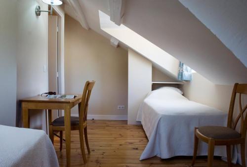 - une chambre avec 2 lits, une table et des chaises dans l'établissement Hôtel Majestic, à Lourdes