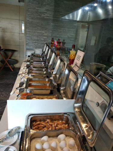 a row of trays filled with eggs and other foods at Royal Orchid Central Vadodara in Vadodara