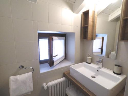a white bathroom with a sink and a window at IRIS 2 lago di Como in Dongo