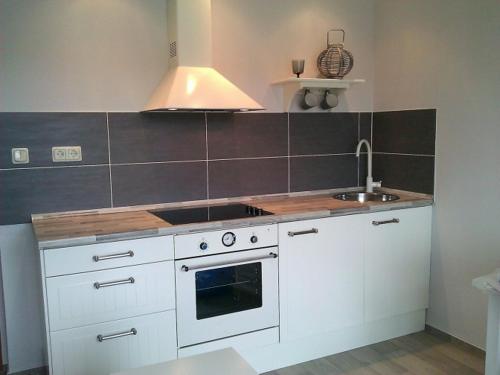 a kitchen with white cabinets and a stove and a sink at Sealounge 239 in Ueckermünde