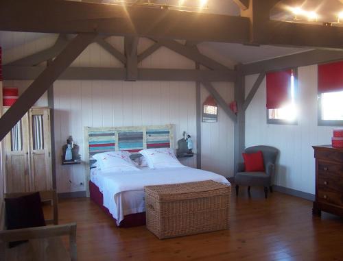 une chambre avec un grand lit et une chaise dans l'établissement La Roulotte de la Vallée du Lot, à Le Temple-sur-Lot