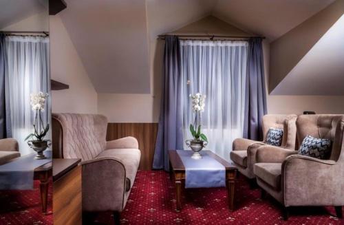 a living room with two couches and a table at Hotel Cristal Park in Dąbrowa Tarnowska