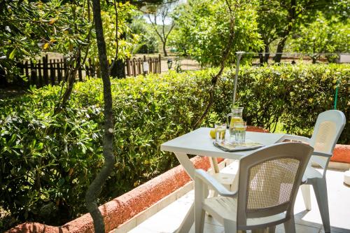 a white table with two chairs and a drink on it at Dendrolivano in Minia