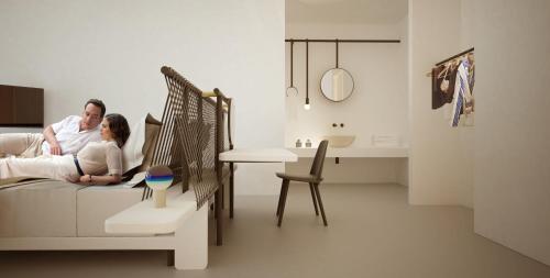a man and woman sitting on a couch in a living room at Alti Santorini Suites - Caldera View in Megalochori