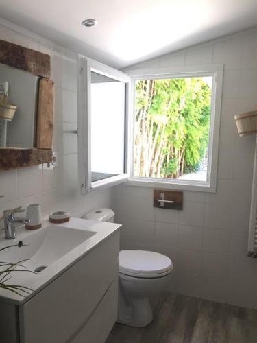 une salle de bain blanche avec toilettes et fenêtre dans l'établissement Tamina, à Andernos-les-Bains