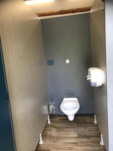 a bathroom with a toilet and a toilet paper dispenser at Camping Frédéric Mistral in Castellane