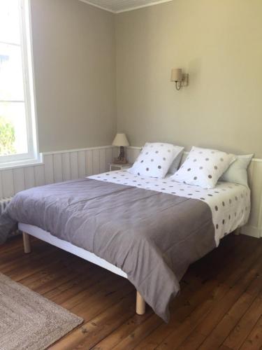 une chambre avec un grand lit avec des oreillers dans l'établissement Tamina, à Andernos-les-Bains