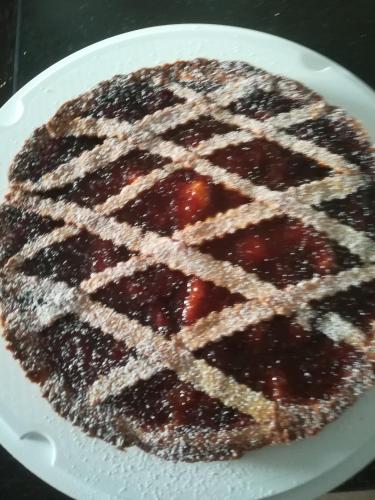 una torta su un piatto bianco con sopra delle fragole di Le Terre Di BAC a Borgo Montenero