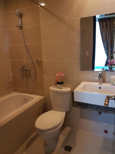 a bathroom with a toilet and a tub and a sink at Apartment Sea View at Mactan Newtown in Mactan