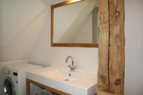 ein Bad mit einem Waschbecken und einem Spiegel in der Unterkunft Beautiful apartments - Romantic in Liepāja