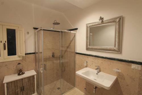 a bathroom with a sink and a shower with a mirror at La Casa del Mercante in Racale