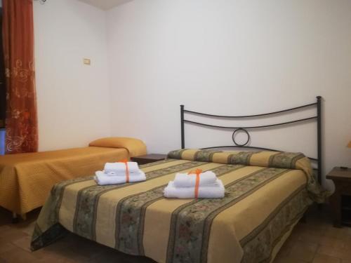 una camera con due letti e asciugamani di Le Terre Di Bac a Borgo Montenero