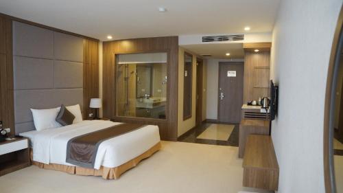 a bedroom with a large bed and a bathroom at Muong Thanh Luxury Ha Nam in Phủ Lý