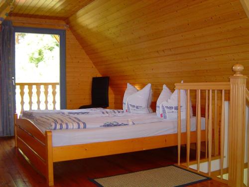 a bed in a wooden room with a window at Reethaus im Ostseebad Trassenheide in Trassenheide