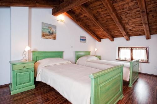 two beds in a room with wooden ceilings at Villa Ester in Rovinj