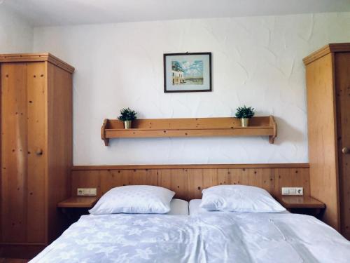 a bedroom with two beds and a shelf on the wall at Pension Zur schönen Aussicht in Heigenbrücken