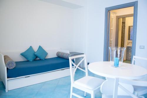 a room with a blue couch and a table and a stool at Hotel Cutimare - Aeolian Charme in Acquacalda