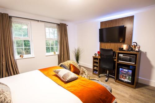 a hotel room with a bed and a television at Trivelles Gatwick Hotel & airport Parking in Crawley