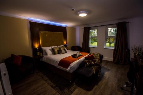 a bedroom with a bed and a chair and a window at Trivelles Gatwick Hotel & airport Parking in Crawley