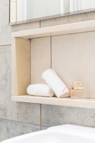 - une étagère avec 2 serviettes et un panier dans l'établissement Hotel La Baia, à Bari