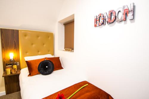 a bedroom with a bed with a head board at Trivelles Gatwick Hotel & airport Parking in Crawley