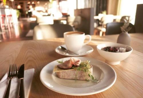 a table with a plate of food and a cup of coffee at Comfort Hotel Västerås in Västerås