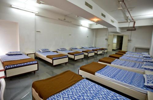 a group of beds lined up in a room at Ramoji Sahara Shared Accommodation in Pedda Ambarpet