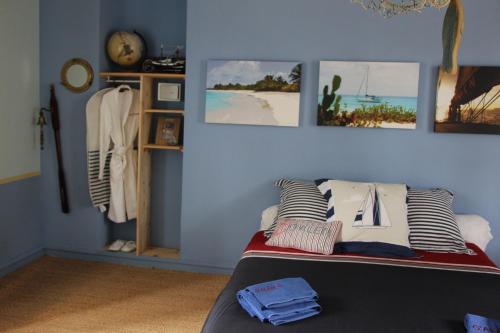 um quarto com uma cama com almofadas e fotografias na parede em La Tocade Del Arte - Dinan em Lanvallay