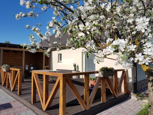 una terraza de madera con una mesa y un árbol en Dreilini Residence en Dreiliņi