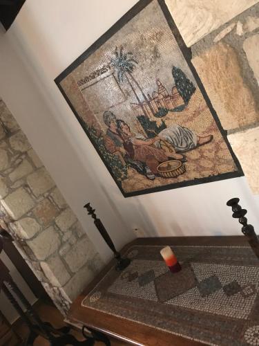 a room with a table and a tapestry on the wall at De Michanna in Anarita