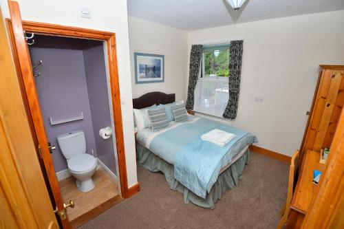 Dormitorio pequeño con cama y aseo en Home from Home Guesthouse en Leiston