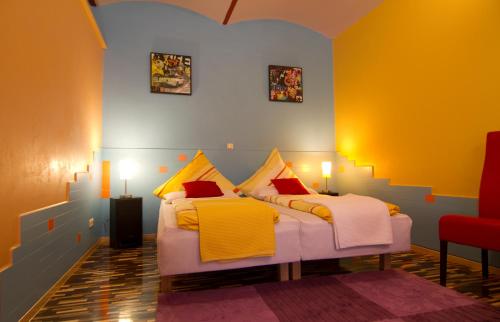 two beds in a room with yellow and blue at Art Apartments in Dresden