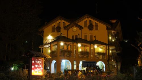 a building with a sign in front of it at night at Hotel Bella di Bosco in Malè