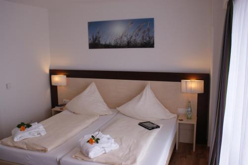 a white bed with two white towels on it at Hotel im Kornspeicher in Marburg an der Lahn