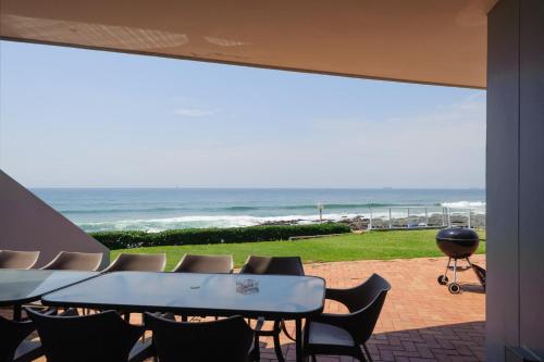 a patio with a table and chairs and the ocean at Suntrap 6 - FAMILY ONLY in Ballito