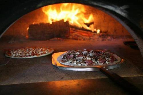 two pizzas are being cooked in an oven at Il Casale Di Roma in Prima Porta