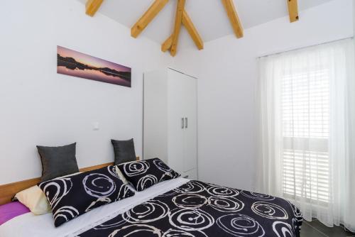 Un dormitorio con una cama con almohadas blancas y negras. en Apartments Trabakul, en Trogir