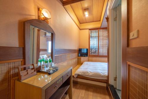 a bathroom with a vanity and a bed in a room at Shankou Hotspring Hotel in Jiaoxi