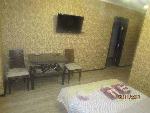 a bedroom with a bed and a tv on the wall at Salus in Khmelʼnytsʼkyy