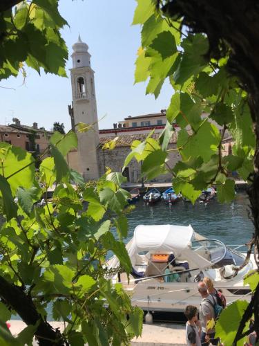a clock tower with a boat in a harbor at Lacisivm Lake View in Lazise